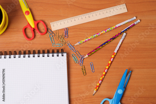 Top view of office tools with blank notebook on wooden table