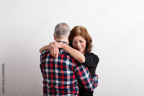 Beautiful senior couple in love hugging. Studio shot.