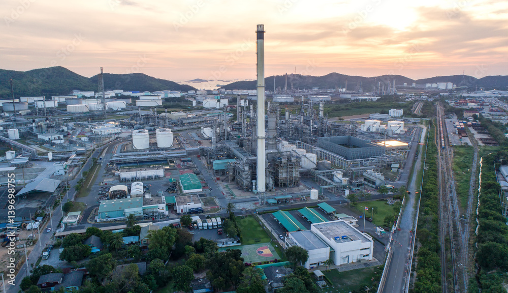 Obraz premium Aerial view Oil refinery with a background of mountains and sky.The factory is located in the middle of nature and no emissions. The area around the air pure.