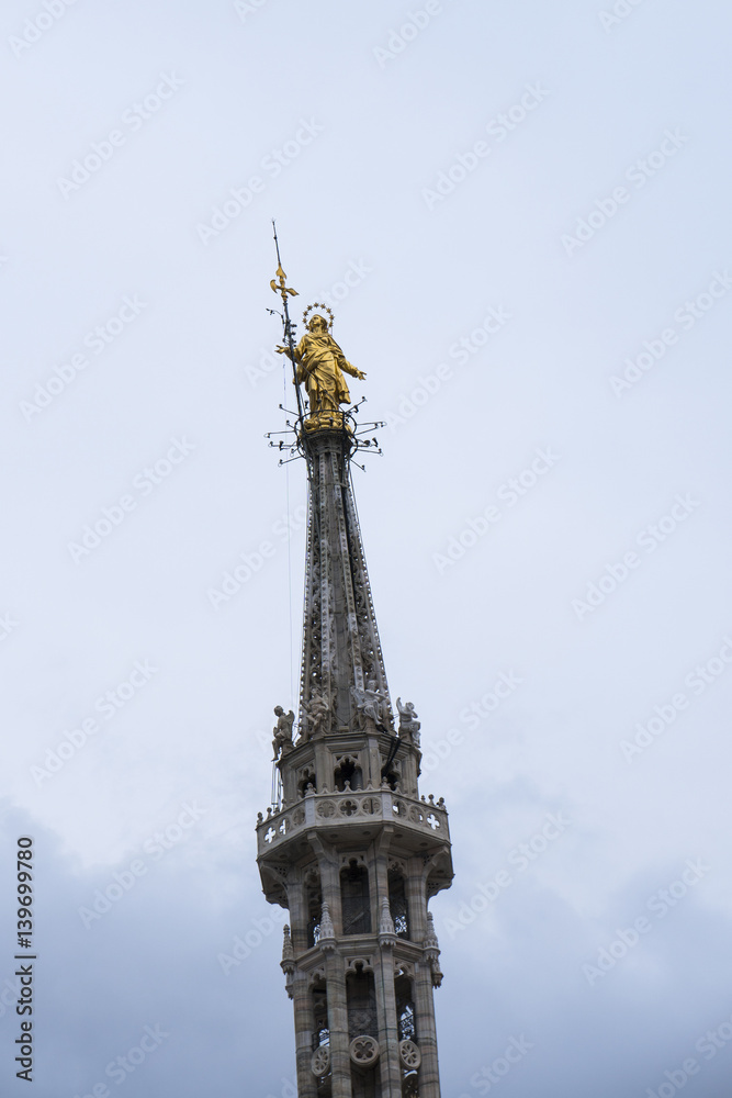 Golden Madonnina: this statue is placed on the highest spire of the Milan cathedral (Duomo di Milano), Italy. Golden Madonnina: this statue is placed on the highest spire of the Milan cathedral (Duomo di Milano), Italy.