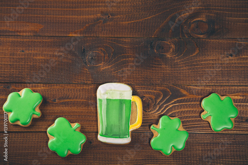 Beautiful background for St. Patrick's day with clover gingerbread and a glass of green beer on a wooden table. Free space