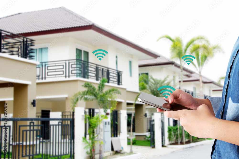 Hand holding smart phone over wifi icon and blur house background ...