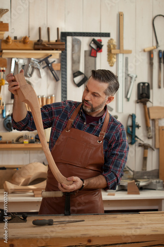 Joiner Makes Cabriole Leg for Vintage Table/Carpenter works with a planer in a workshop for the production of vintage furniture. He makes cabriole leg for a table in the style of Louis XV, Queen Anne photo