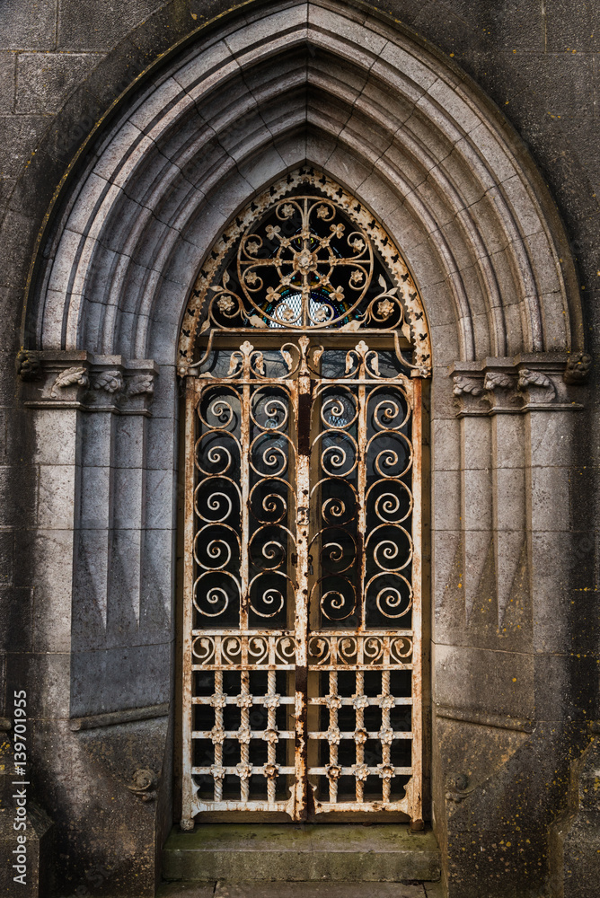 Fototapeta premium Graveyard tomb door Rusty locked gate archway 