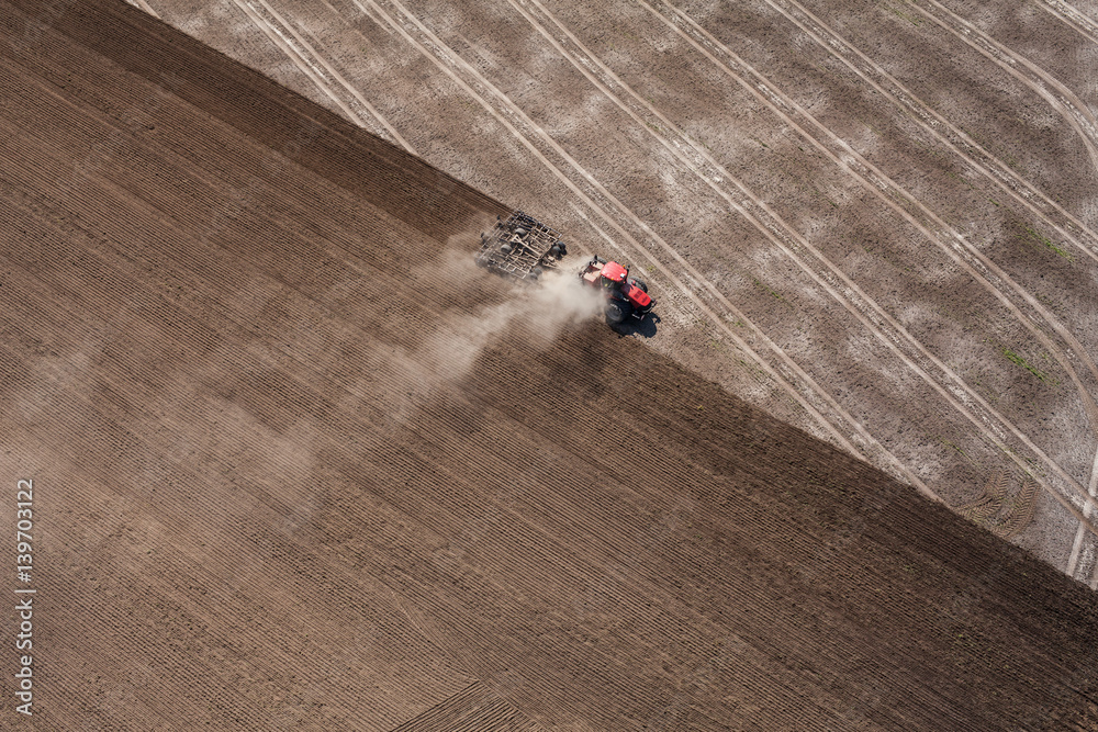 aerial view of the tractor working on the harvest field aerial view of the tractor working on the harvest field