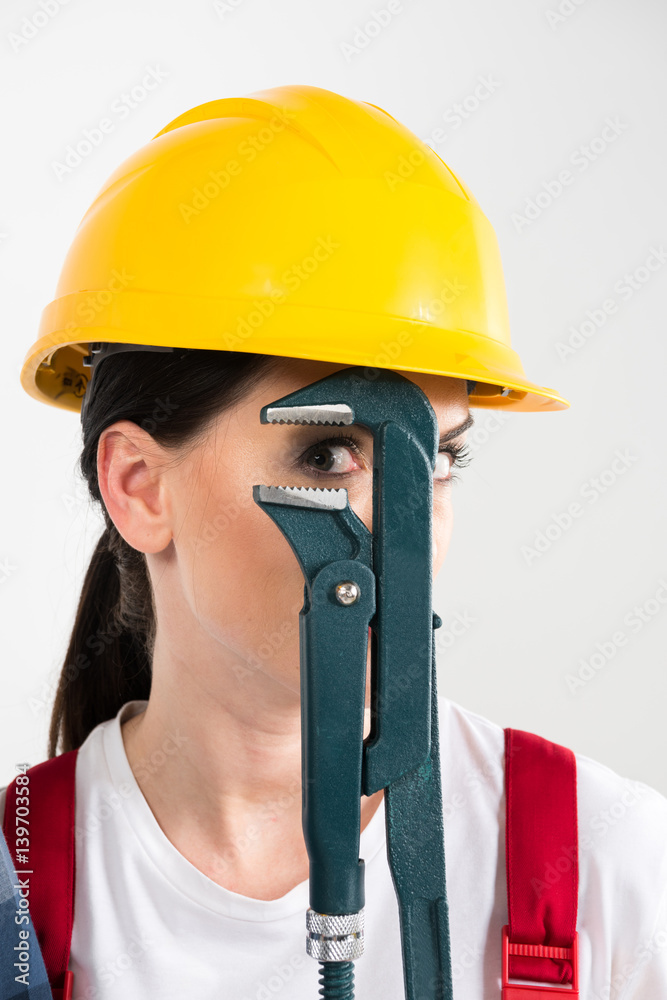 Female builder holding wrench Female builder holding wrench