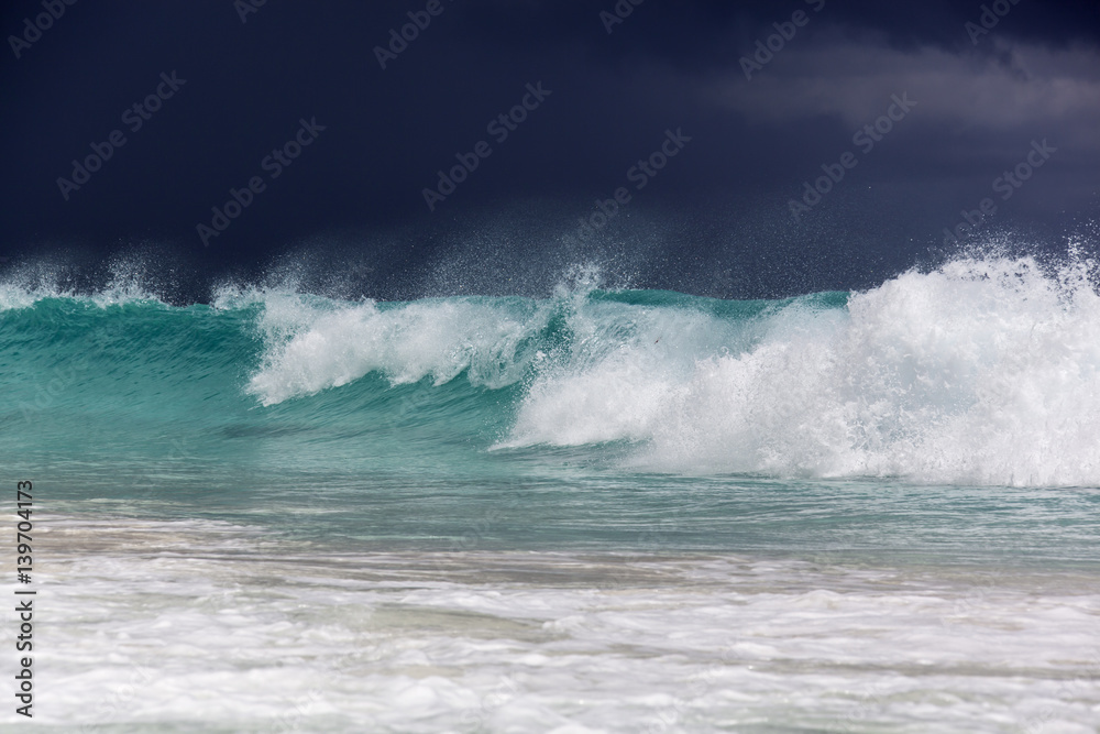 Big waves at Grande Anse beach before thunderstorm at the island La Digue, Seychelles