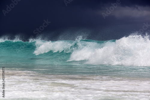 Big waves at Grande Anse beach before thunderstorm at the island La Digue, Seychelles