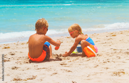 kids play with sand on summer beach photo