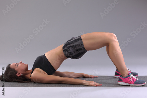 Fototapeta Naklejka Na Ścianę i Meble -  Attractive woman do fitness exercise on a mat