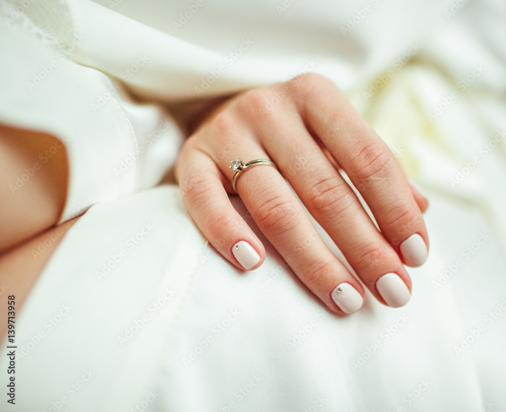 Close-up of tender ring on bride's hand with white nails Close-up of tender ring on bride's hand with white nails
