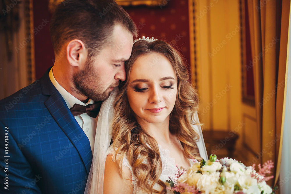 Groom in plaid blue jacket hugs bride tender Groom in plaid blue jacket hugs bride tender