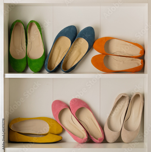 Rows of colorful women's shoes (ballet shoes) in the wardrobe.