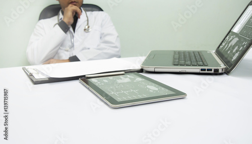 medicine doctor working with computer notebook and digital tablet at desk in the hospital