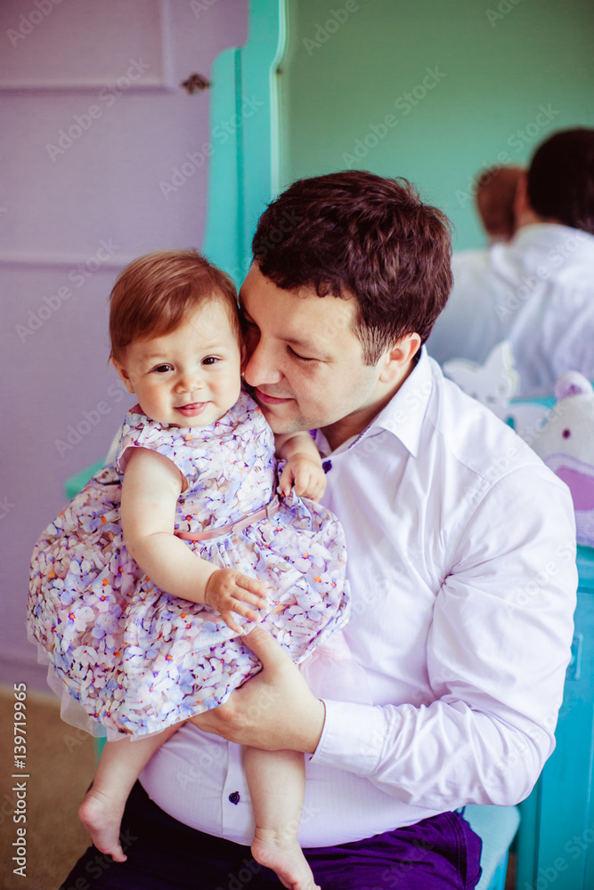 Dreamy father leans to his little daughter tender while they sit before mirror Dreamy father leans to his little daughter tender while they sit before mirror