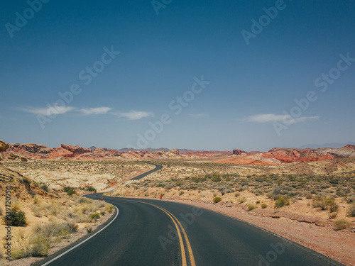 A windy empty road going through the hot summer desert of las vegas, nevada