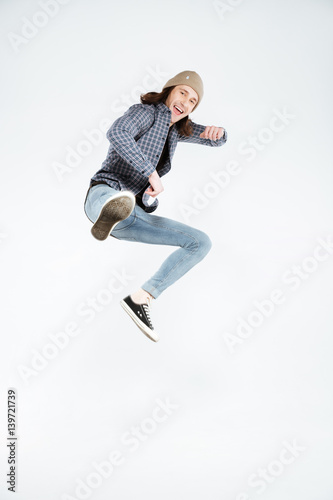 Vertical image of Hipster jumping at camera