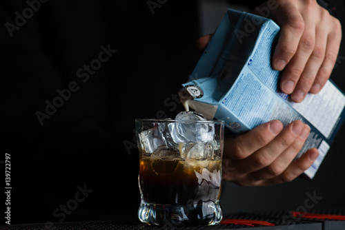 bartender in a nightclub pouring cocktail