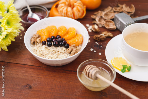 Oatmeal with fruit and berries on a wooden background.