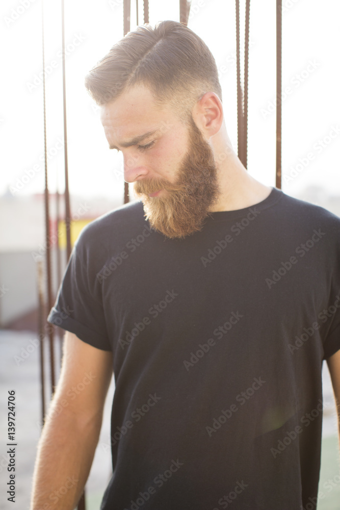 Bearded man posing in the street.