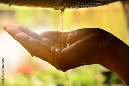 Water drop in to the hand of woman and flare light on hand