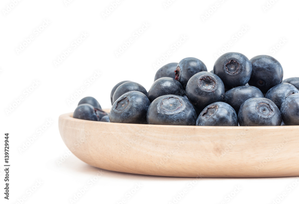 blueberry fruit in wooden plate isolated on white background blueberry fruit in wooden plate isolated on white background