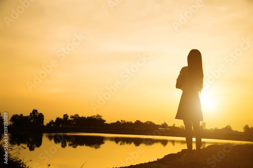 Fotografie, Tablou Silhouette of woman praying over beautiful sky background