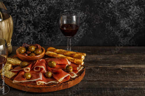 Prosciutto, cracker, bread sticks with red wine.