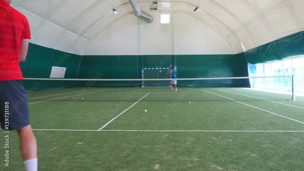 Two men playing tennis on the grass court Two men playing tennis on the grass court