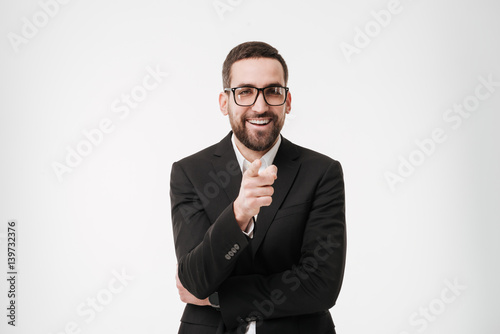 Young bearded businessman pointing to camera.