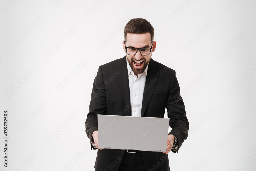 Screaming businessman using laptop computer. Screaming businessman using laptop computer.