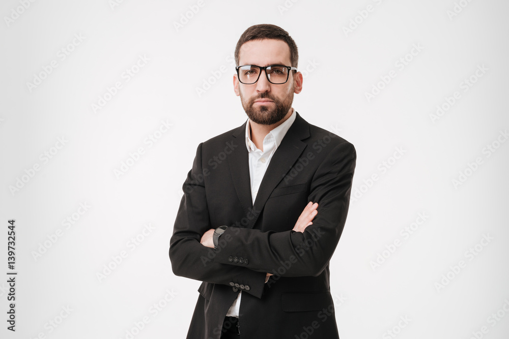 Serious businessman standing with arms crossed. Serious businessman standing with arms crossed.