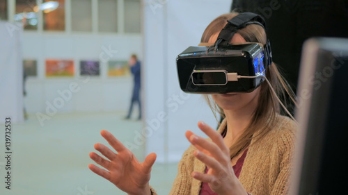 Virtual reality game. Young woman using virtual reality glasses. VR
