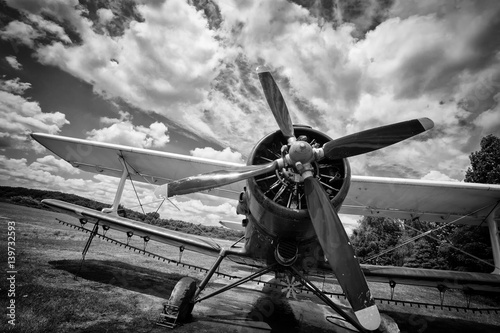 Billede på lærred Old airplane on field in black and white