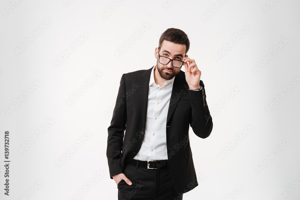 Serious young bearded businessman wearing glasses Serious young bearded businessman wearing glasses