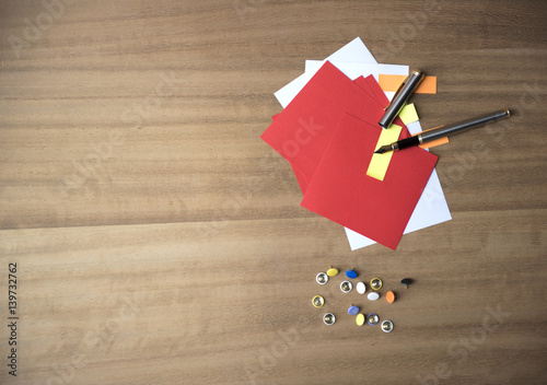 Plakat w ramie Multi coloured note paper with drawing pins and a pen on a wooden background