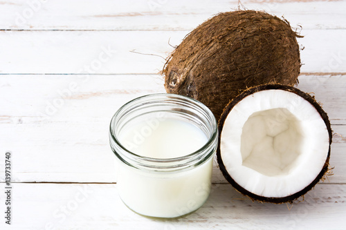 Coconut and coconut milk on white wooden table
