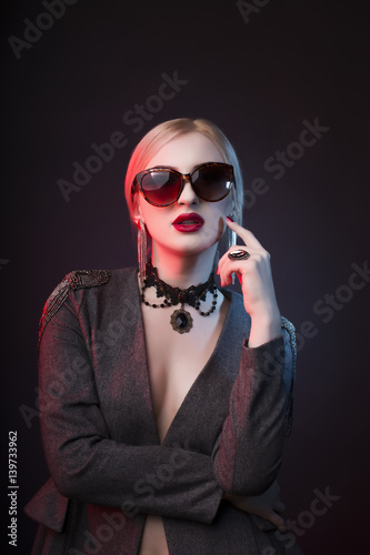 Glamorous blonde lady in glasses with bright makeup