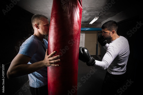 Young man practicing kickboxing punches with his coach