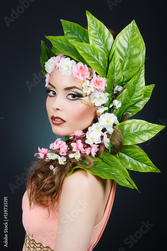 Fototapeta Naklejka Na Ścianę i Meble -  Beauty Spring girl with flowers hair. Beautiful model woman with flowers on her head. The Nature Of Hairstyle. Summer. Spring. Holiday Creative Makeover. Makeup Fashion. Makeup. Vogue Style Portrait