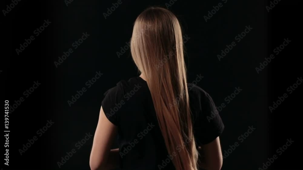 Back view woman letting down blond straight hair