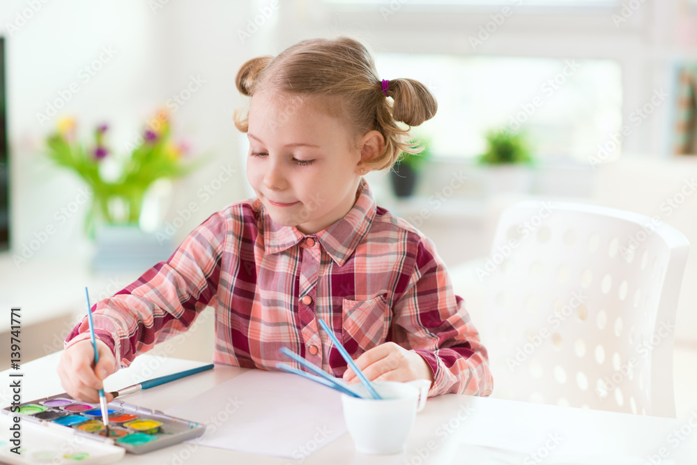 Pretty little child girl painting with colorful paint at home Pretty little child girl painting with colorful paint at home