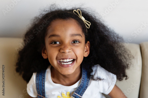 Portrait d'une petite fille qui rit sur le canapé photo