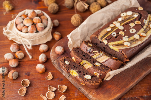 Chocolate cake with banana and hazelnut on a wooden background