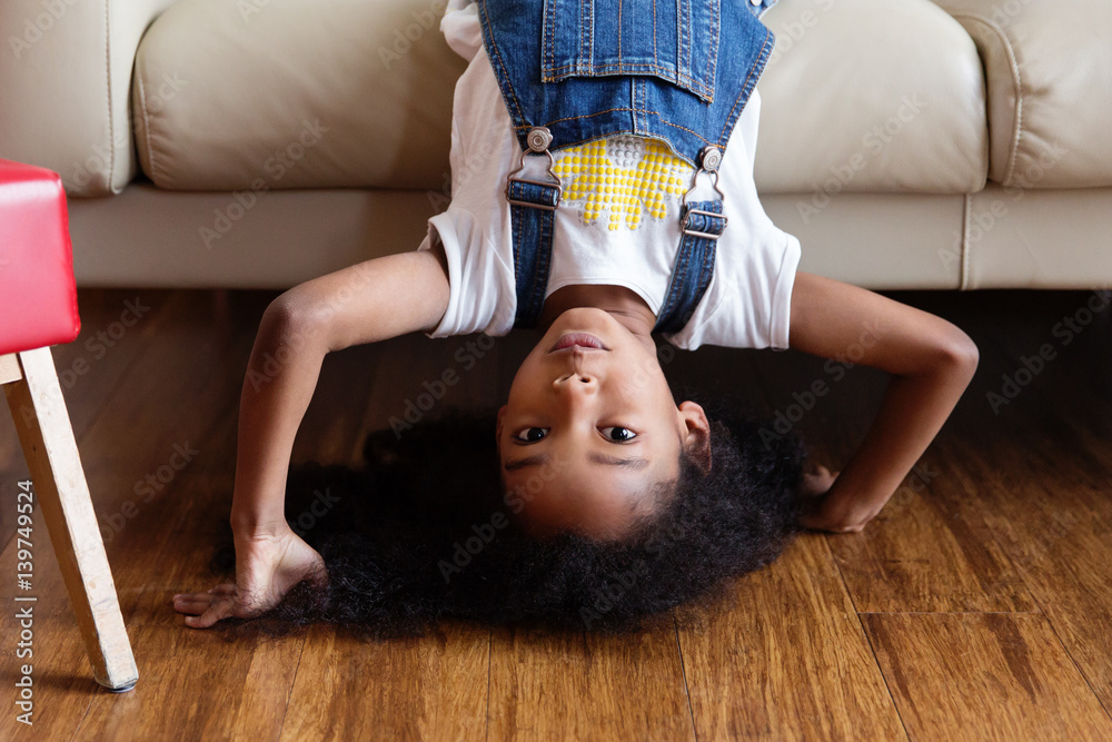 petite fille la tête à l'envers sur le canapé du salon Stock Photo