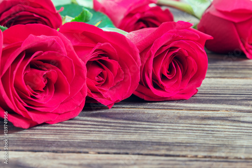 red three roses on a wooden background