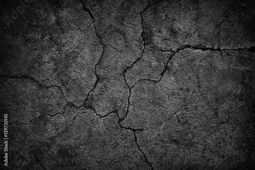 cracked concrete wall covered with black cement texture as background for design photo