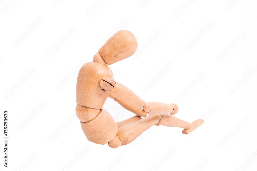 Depressed and sad wooden doll on a white background. Bad emotions concept.