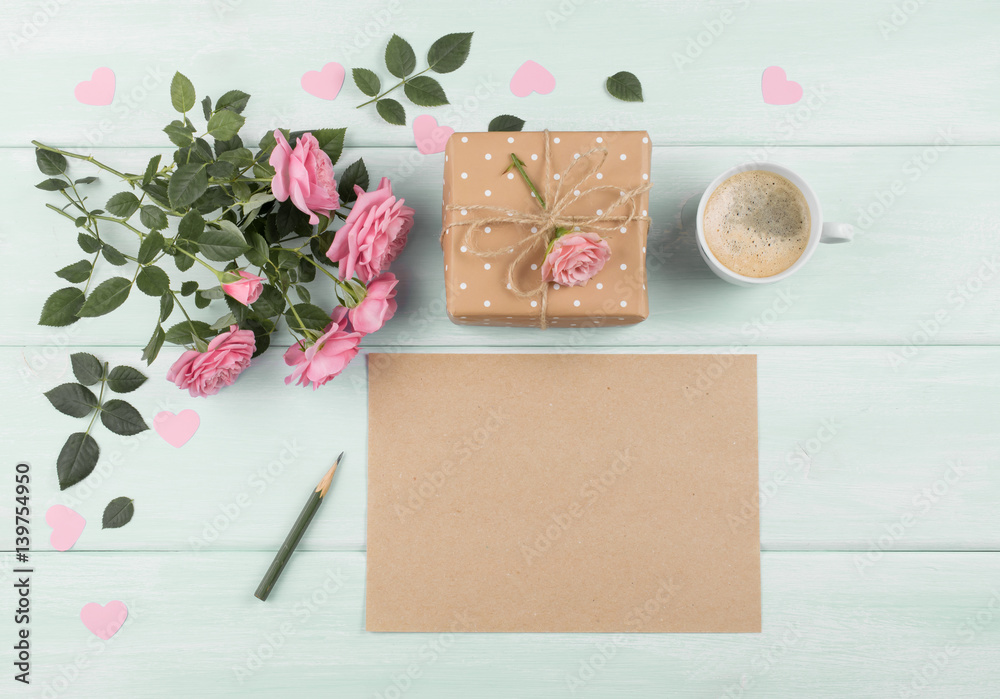Roses with sheet paper for greeting text, gift box and coffee cup on background of wooden planks Roses with sheet paper for greeting text, gift box and coffee cup on background of wooden planks