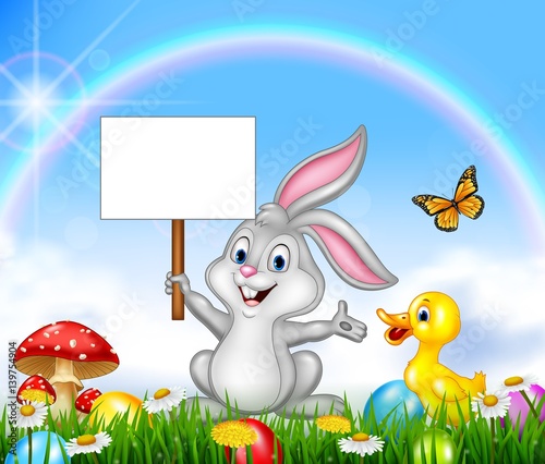 Happy little bunny holding blank sign with Easter background